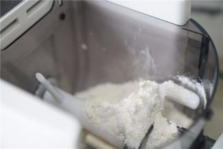 将面粉入面条机里。