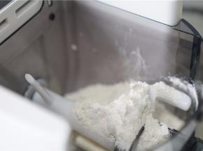 将面粉入面条机里。