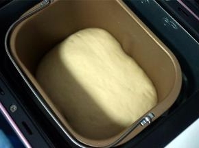 将面团放入面包机，选择酸奶程序发酵至面团两倍大，约1.5至2个小时。