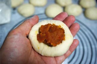 分别包上南瓜馅料，馅料约一个汤圆大小。捏紧，收口朝下。