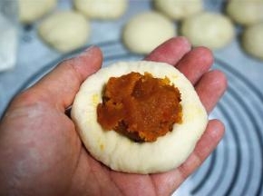 分别包上南瓜馅料，馅料约一个汤圆大小。捏紧，收口朝下。