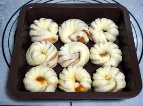 将面包坯排放入模具中，放入烤箱进行二次发酵，约40分钟。