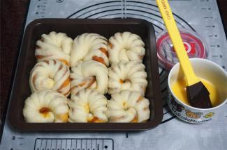 在每个面包坯表面刷上一层全蛋液，放入预热好的烤箱中层，180度上下火，烘烤15分钟即可。