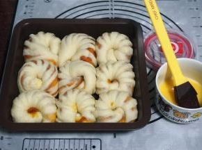 在每个面包坯表面刷上一层全蛋液，放入预热好的烤箱中层，180度上下火，烘烤15分钟即可。