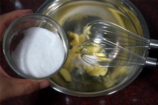 黄油软化后，分次加入细砂糖，搅打融合。