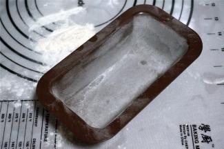 模具抹上黄油，均匀撒上高筋粉，然后倒扣出多余的高筋粉，备用。