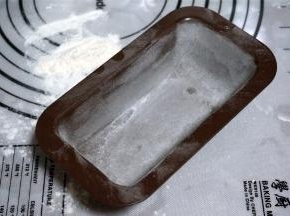 模具抹上黄油，均匀撒上高筋粉，然后倒扣出多余的高筋粉，备用。