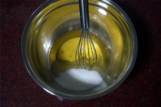 将玉米油，细砂糖，三分之二的全蛋液同放入打蛋盆中，拌均匀。