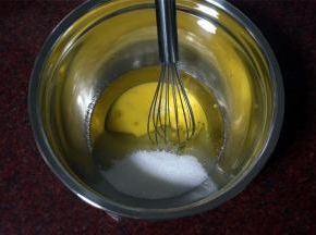 将玉米油，细砂糖，三分之二的全蛋液同放入打蛋盆中，拌均匀。