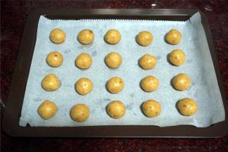 烤盘铺上油性纸。面团分成10克一份，揉圆，排入烤盘。