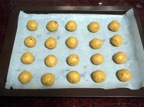 烤盘铺上油性纸。面团分成10克一份，揉圆，排入烤盘。