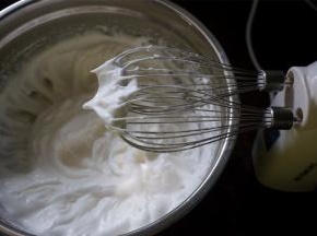 蛋白分次加入50克细砂糖，打发至硬性发泡状态，如图。