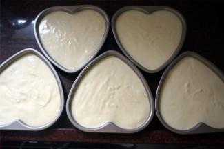 将蛋糕糊尽量平均分配到5片6寸的心形模具中，并震荡出大气泡。