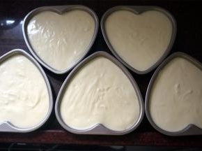 将蛋糕糊尽量平均分配到5片6寸的心形模具中，并震荡出大气泡。