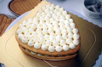 蛋糕片正面朝上放置在底托上，然后挤出淡奶油圆点，如图。