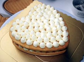 蛋糕片正面朝上放置在底托上，然后挤出淡奶油圆点，如图。