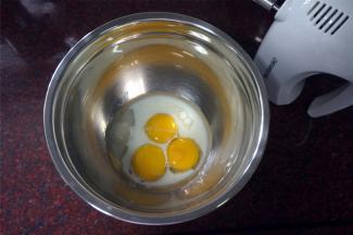 制作面糊：蛋黄中加入13克细砂糖，20克纯牛奶或清水，33克玉米油，拌至糖融化。