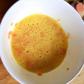 4、	鸡蛋打入碗中，倒入火腿碎搅匀