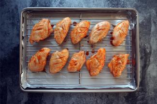 烤箱上下火200度预热。烤盘垫上一层锡纸（避免事后洗刷的痛苦），然后放入烤架，排上鸡翅，放入烤箱中层，烤30分钟。