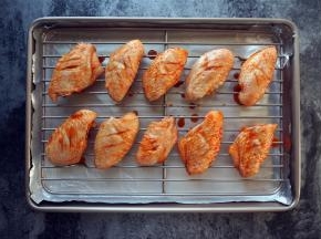 烤箱上下火200度预热。烤盘垫上一层锡纸（避免事后洗刷的痛苦），然后放入烤架，排上鸡翅，放入烤箱中层，烤30分钟。