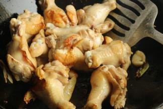 炒锅放少许油，放入鸡翅根煎香表面。