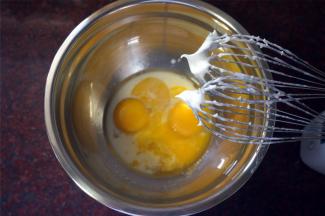 制作面糊：蛋黄中加入13克细砂糖，20克纯牛奶或清水，33克玉米油，拌至糖融化。