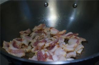 锅里加少许的油，将腌制好的五花肉切片下锅煎至出油。