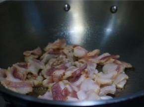 锅里加少许的油，将腌制好的五花肉切片下锅煎至出油。