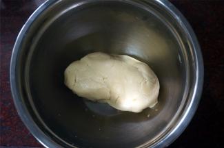 戴上手套，将松散的面粉揉成团。