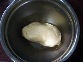 戴上手套，将松散的面粉揉成团。