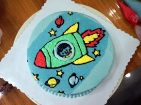 勺少量的白色淡奶油，加入色素调色后，装入裱花袋，然后对图案进行填色。