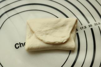 面片上刷少许油，也可以撒椒盐等做成咸口味的，或者加馅。两头折上去成为三层。