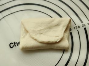 面片上刷少许油，也可以撒椒盐等做成咸口味的，或者加馅。两头折上去成为三层。