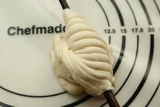 一只手拿筷子，另一只手捏紧下端，转动筷子180度，就成了图上的样子，收口压在筷子下面。