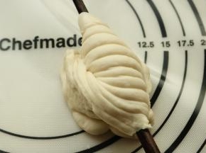 一只手拿筷子，另一只手捏紧下端，转动筷子180度，就成了图上的样子，收口压在筷子下面。