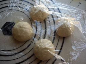 排气，分成4份，揉圆，盖上保鲜膜，松弛静置15分钟。