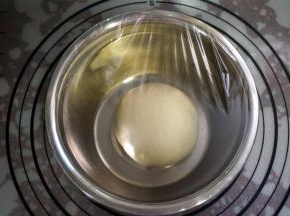 将面团揉圆，盖上保鲜膜，放入烤箱，用发酵程序发酵。