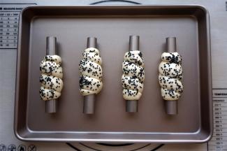 从粗的一端开始卷起，收口朝下，表面刷上清水，撒上黑芝麻。