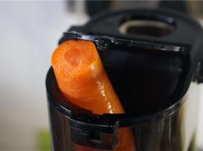 将胡萝卜入原汁机榨取出原汁。