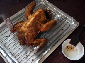 烤盘垫上锡纸，放入一个13寸不粘冷却架，将腌制好的光鸡胸部朝上放在网架上， 鸡翅尖和腿尖用锡纸包裹。烘烤前，给全鸡刷上一层食用油，锁住酱汁。