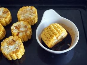 在烤鸡的过程中，将玉米切段，分别在腌鸡的酱料上打滚一圈。