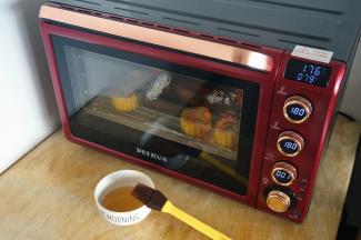 上下大温幅180度烘烤20分钟后，取出给鸡和玉米再刷一次酱料。同时准备麦芽糖水（麦芽糖用适量的热水兑开即可）。剩下最后一分钟时，食物探针显示中心温度176度，鸡内部温度79度，对于一只小鸡来说，这个温度可以让肉熟透了。