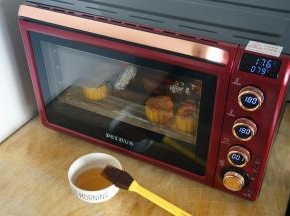 上下大温幅180度烘烤20分钟后，取出给鸡和玉米再刷一次酱料。同时准备麦芽糖水（麦芽糖用适量的热水兑开即可）。剩下最后一分钟时，食物探针显示中心温度176度，鸡内部温度79度，对于一只小鸡来说，这个温度可以让肉熟透了。