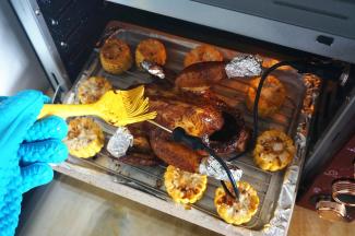 上下大温幅200度烤制20分钟后，将上下温度旋至180度，时间旋至40分钟。同时将玉米段放入烘烤，并给鸡刷上一层腌鸡酱料。