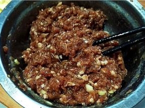 猪肉馅中加入料酒、油、盐、胡椒粉、葱姜，搅拌均匀上劲。