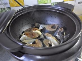 电砂锅里加少许油微热，将腌制好的鱼块平铺在锅里。