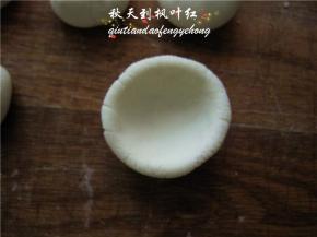 取一面团，用大拇指按一小窝