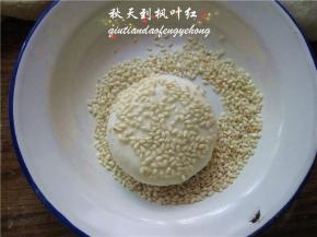 小饼表面稍涂抹些水，然后两面沾上芝麻