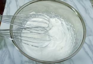 继续打发蛋白出现纹路后转低速打至稍有阻力时，提起打蛋器呈现直立的小尖角即可