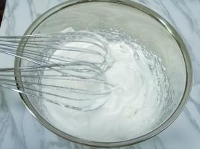 继续打发蛋白出现纹路后转低速打至稍有阻力时，提起打蛋器呈现直立的小尖角即可